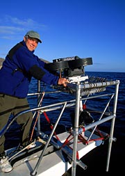 [Photo of James Neihouse on bowsprit of boat]